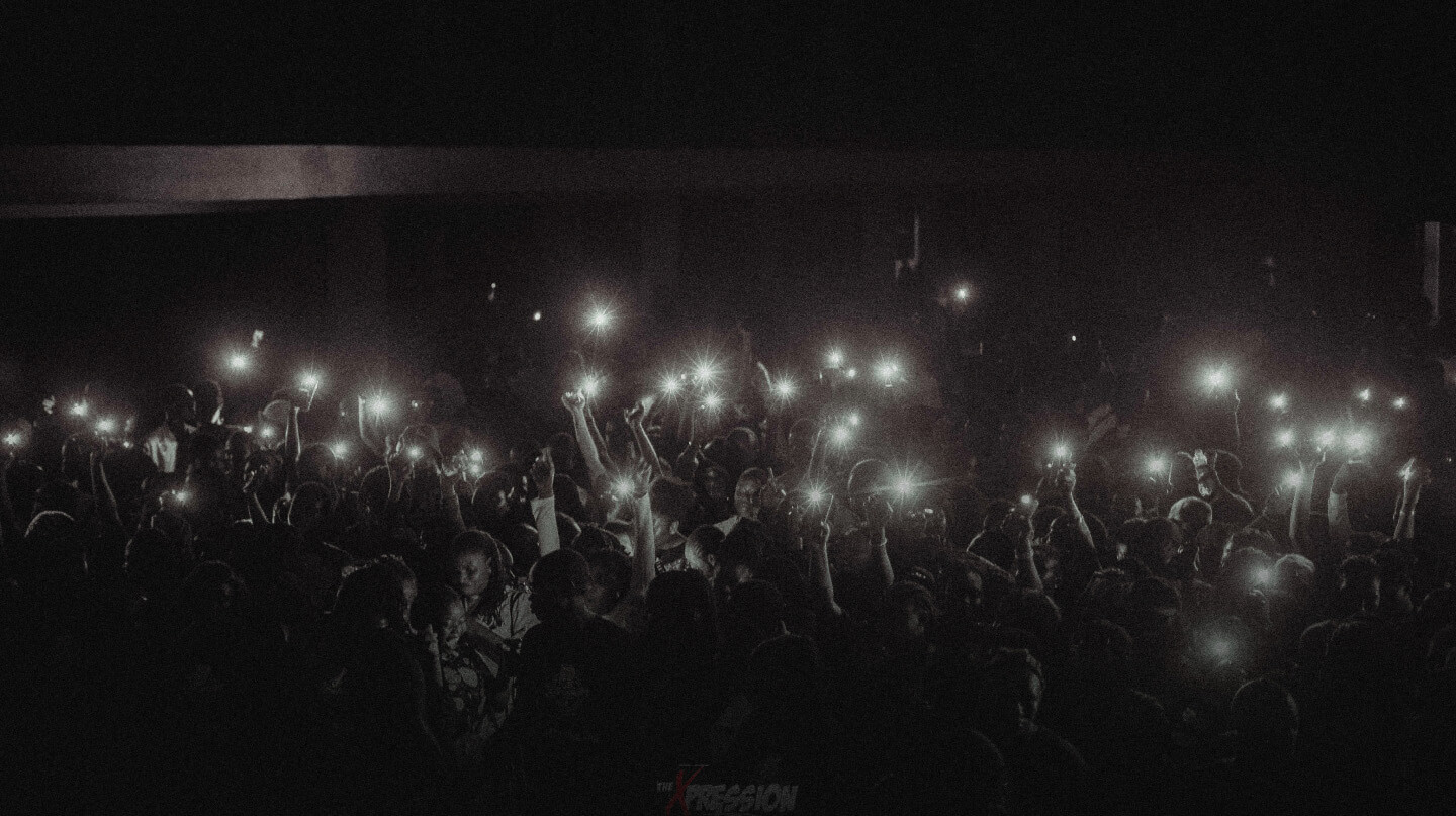 Black and white image of crowd with their flash lights on